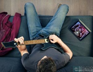 Older teen playing Guitar Hero Live in the Livingroom.