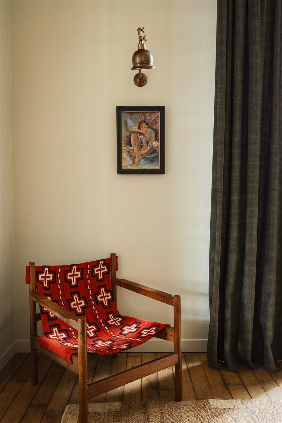 Fauteuil en bois tendu d'un tissu rouge à motifs de croix, applique en laiton
