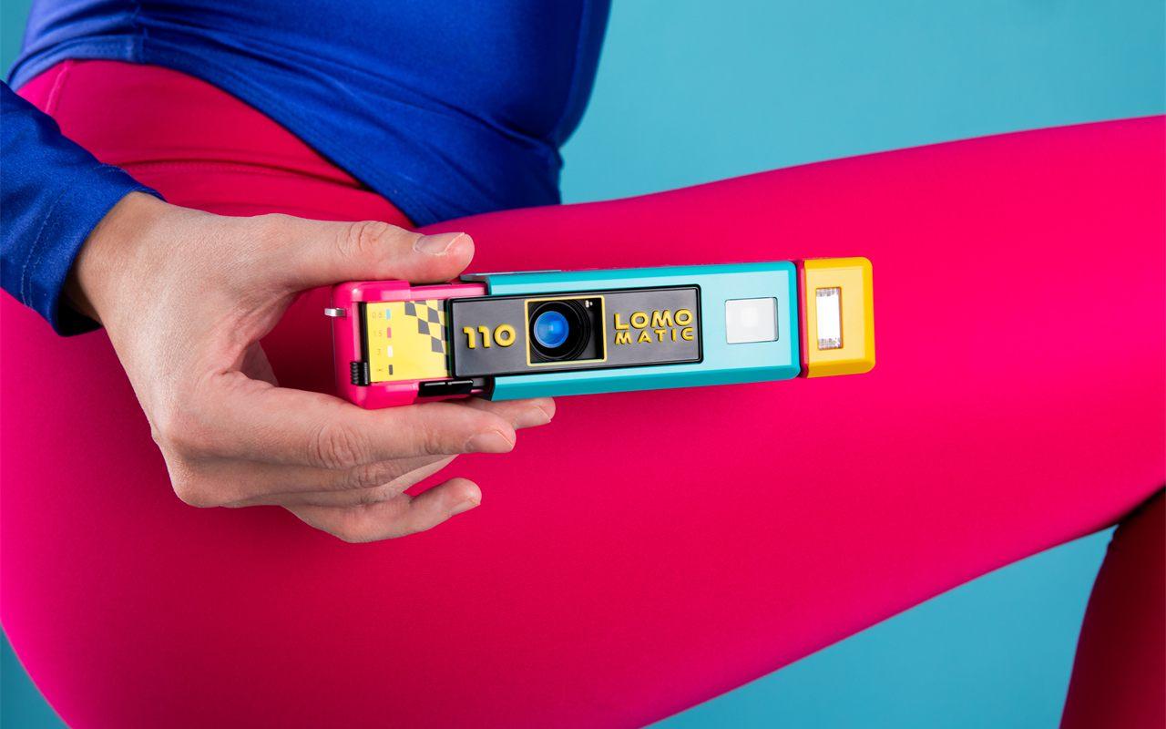 Le Lomomatic 110 Discomatic tenu contre un legging rose vif, ambiance années 80