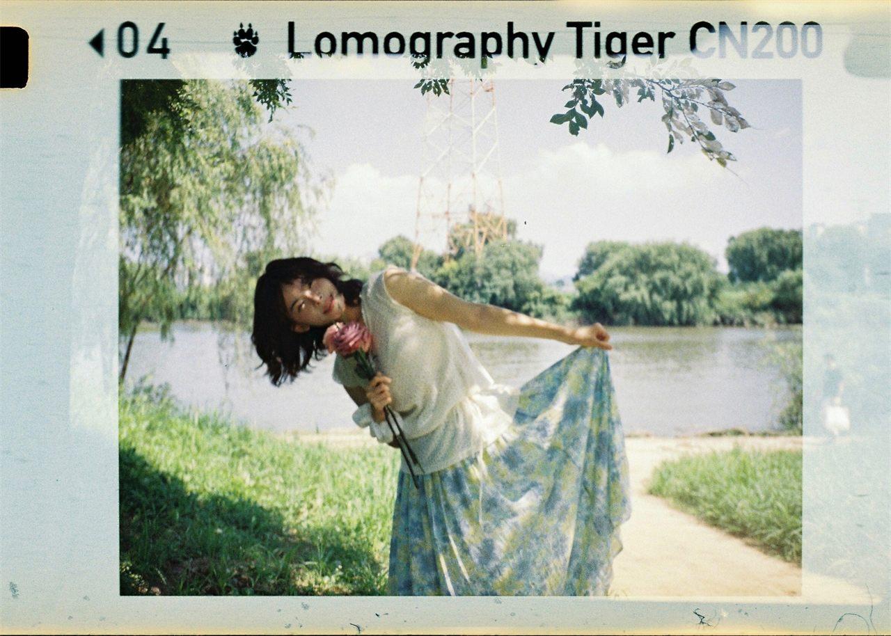 Photo prise au Lomomatic 110, jeune femme au bord de l'eau, rendu argentique doux