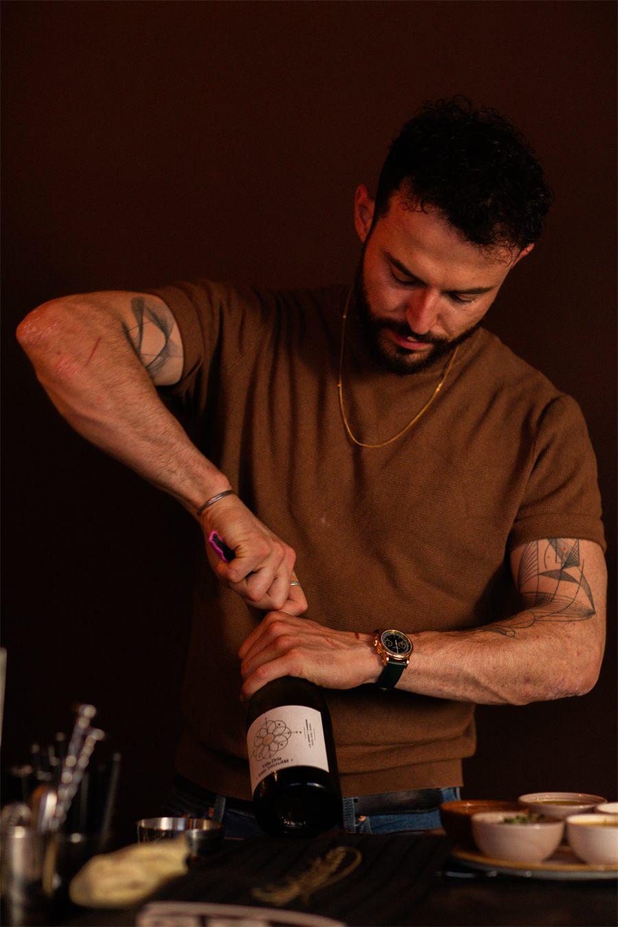 Arthur Auguy, chef de Suki Paris, ouvre une bouteille de vin au bar