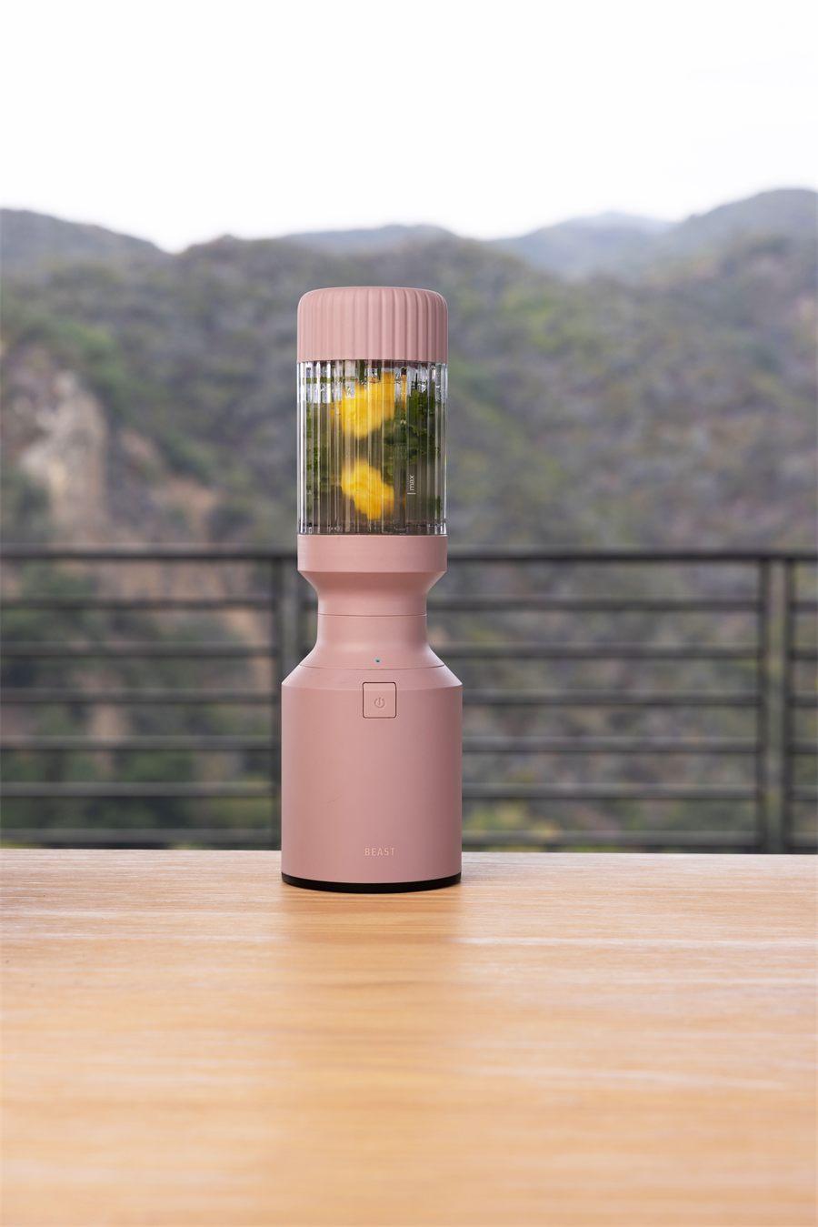 Un blender Beast Health rose posé face à un paysage de montagnes