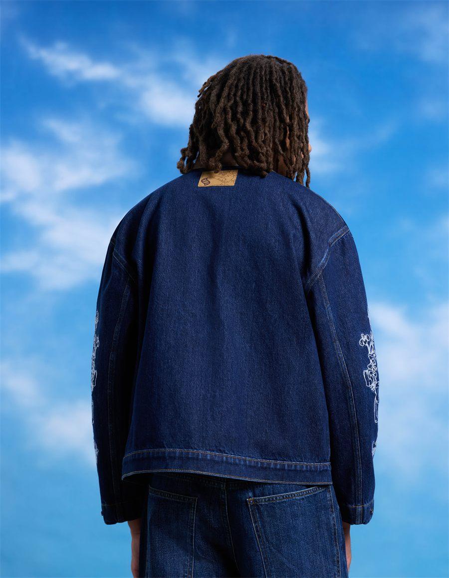 Veste en jean bleu celio x Pokémon portée de dos, broderies blanches sur les manches