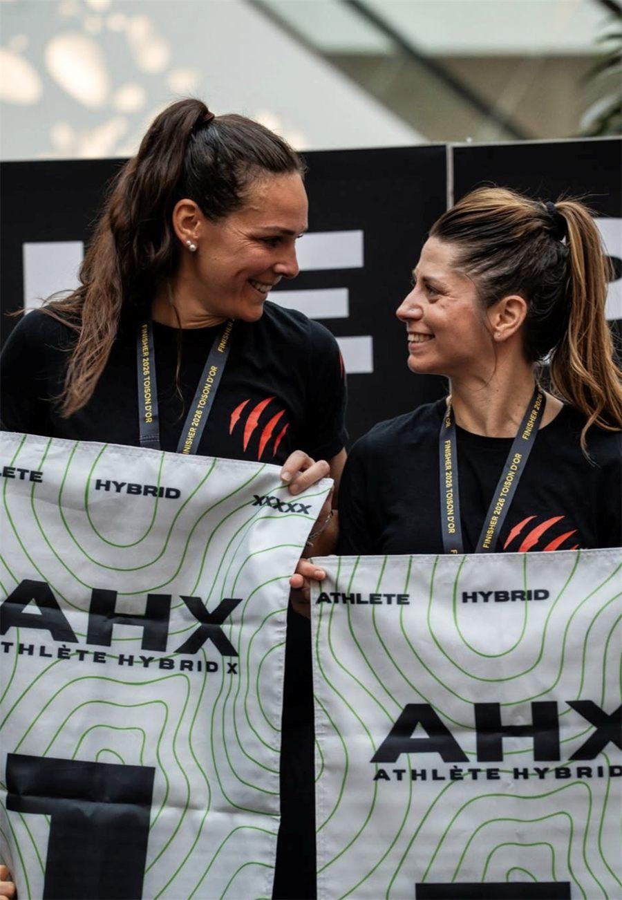 Deux athlètes tenant les drapeaux AHX Athlète Hybrid X