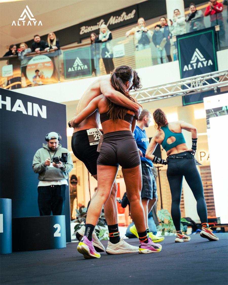 Deux athlètes qui s'étreignent devant le podium ALTAYA