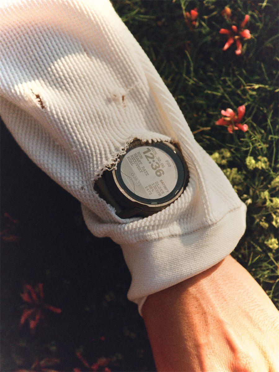 La montre portée sous une manche, posée dans l'herbe de montagne