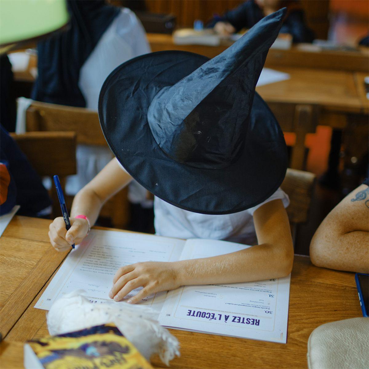Un enfant coiffé d'un chapeau de sorcier participe au Grand Examen