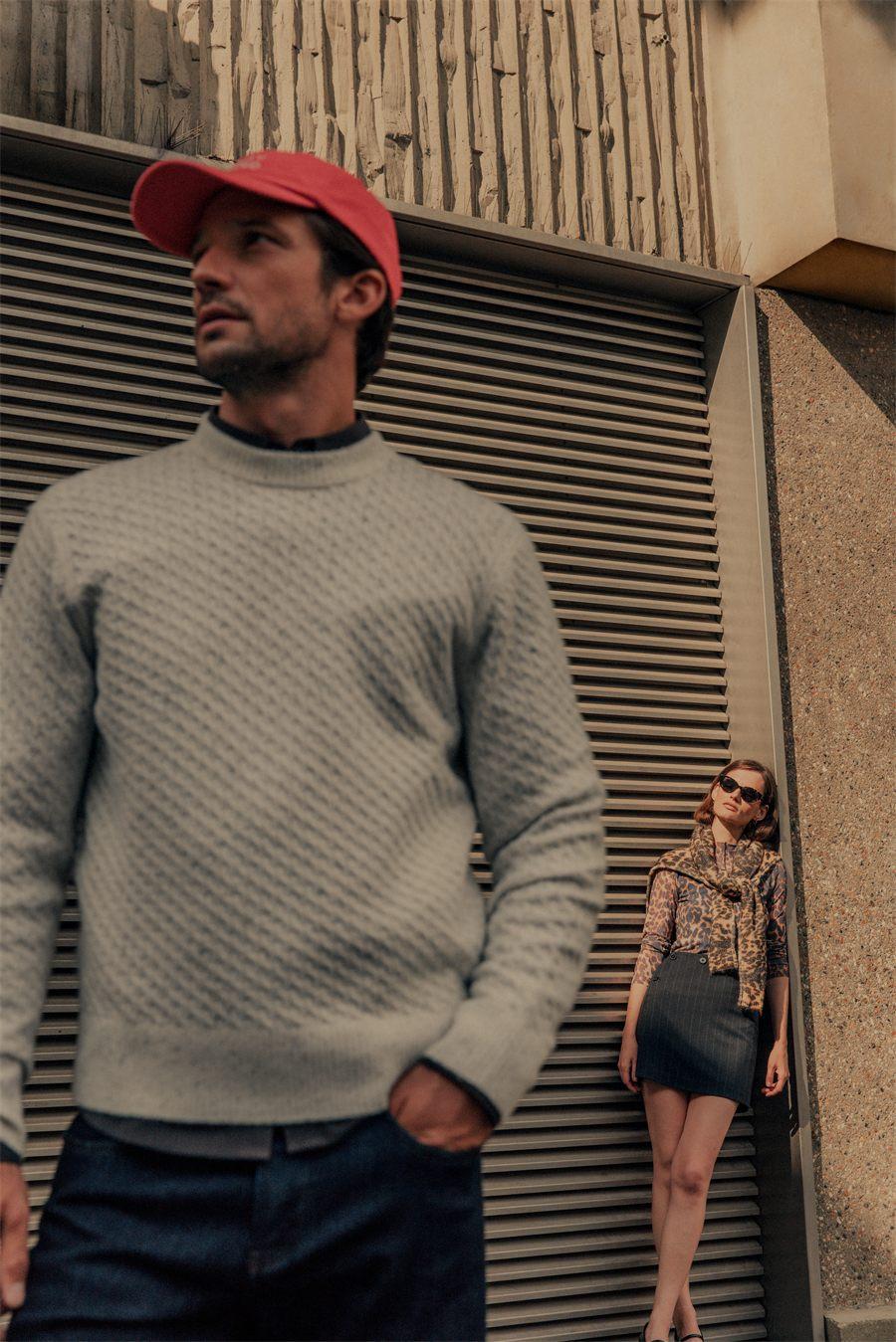 Pull matelasse gris porte avec une casquette rouge