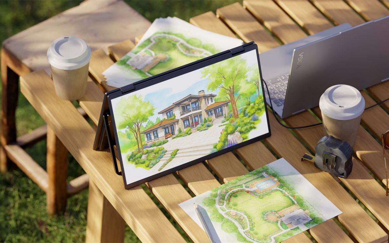 Ecran portable Japannext en mode chevalet sur une table de jardin, a cote de plans d'architecte