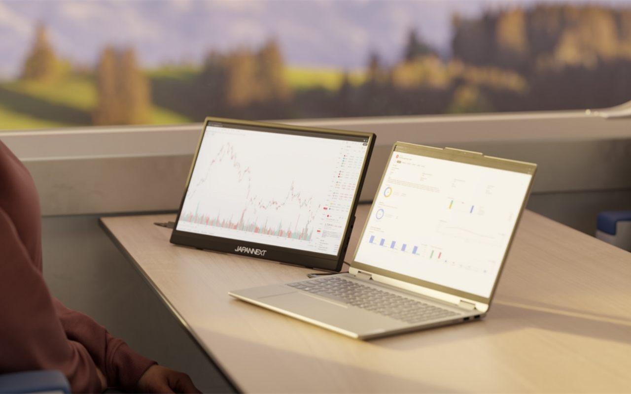 Ecran portable Japannext pose a cote d'un ordinateur portable sur une tablette de train