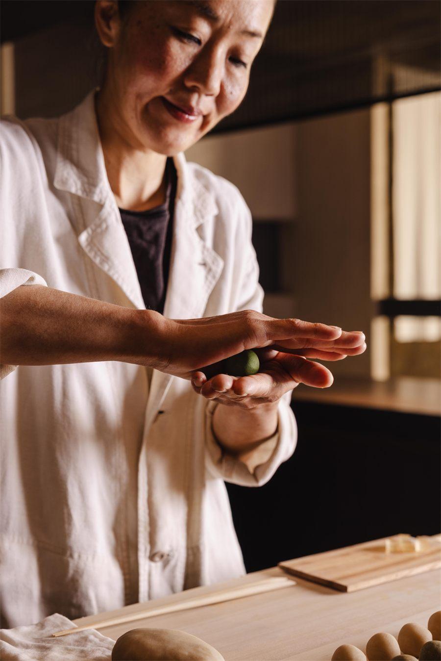 Miki Ishii faconne un hitokuchigashi au the matcha dans le creux de sa paume