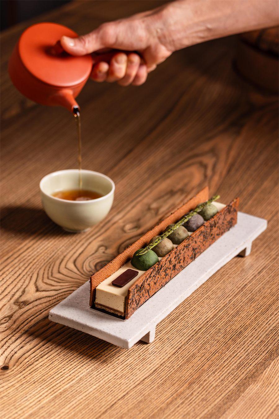 Theiere rouge versant le the Icho-Hojicha pres de la patisserie