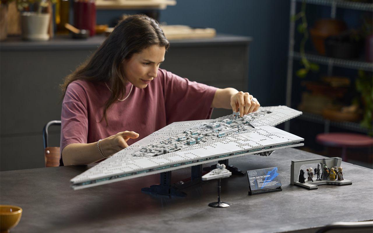Femme assemblant le set LEGO Star Wars Executor sur une table