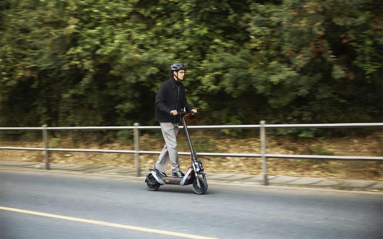 La trottinette électrique NAVEE NT5 Max sur une route bordée de verdure
