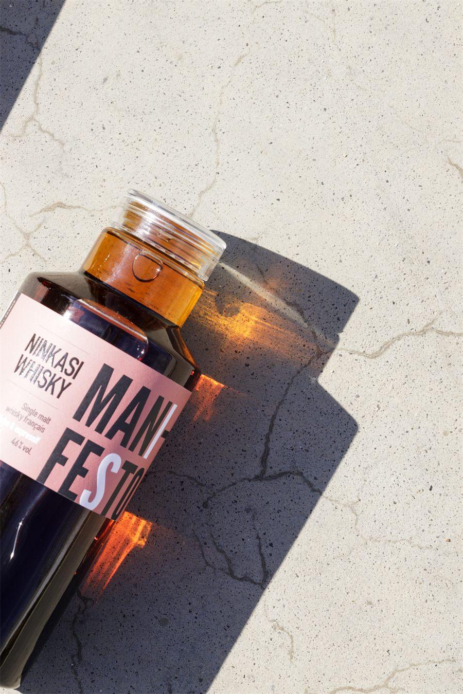 Gros plan sur la bouteille Ninkasi Whisky Manifesto et son etiquette rose