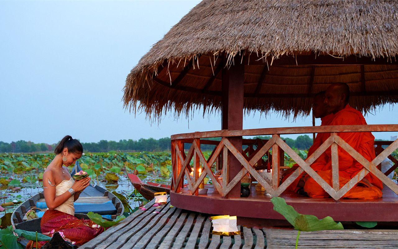 Soiree du lotus de l'Anantara Angkor Resort, barque et pavillon de chaume au crepuscule