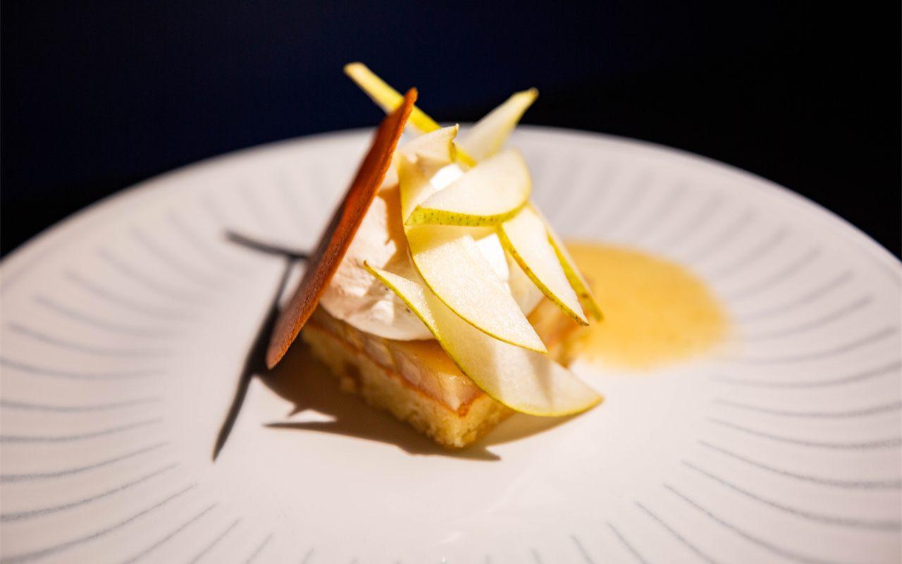 dessert dresse sur assiette blanche, lamelles de poire et creme