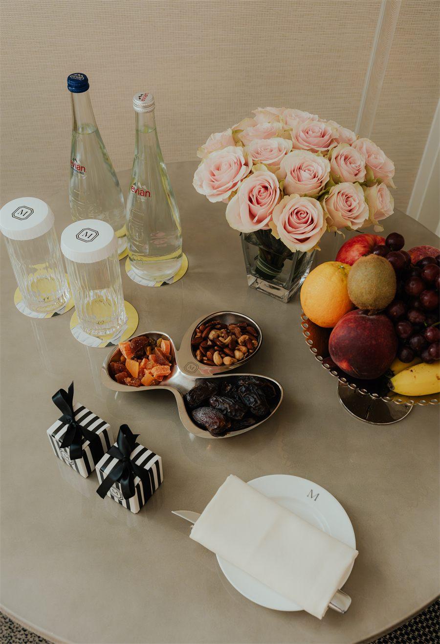 Ravier chromé garni de fruits secs et coffrets rayés sur une table du Mark