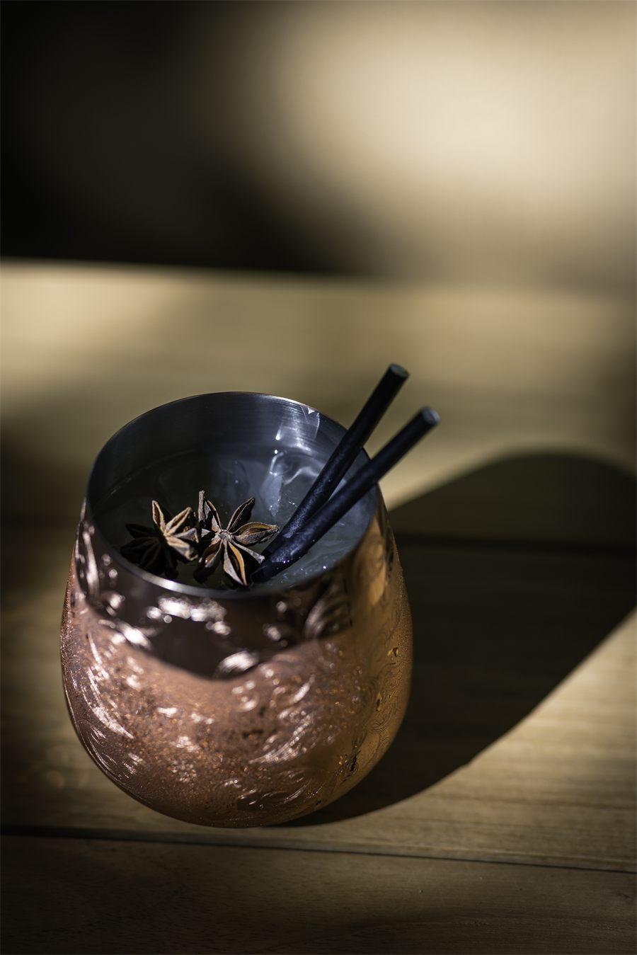 Timbale en cuivre ciselé garnie de glace et de deux anis étoilés