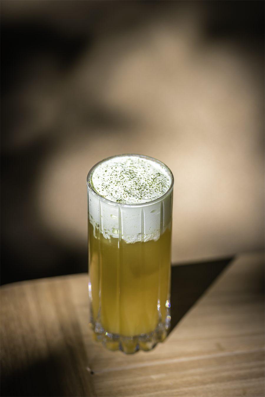 Long drink coiffé d'une mousse blanche saupoudrée de thé vert