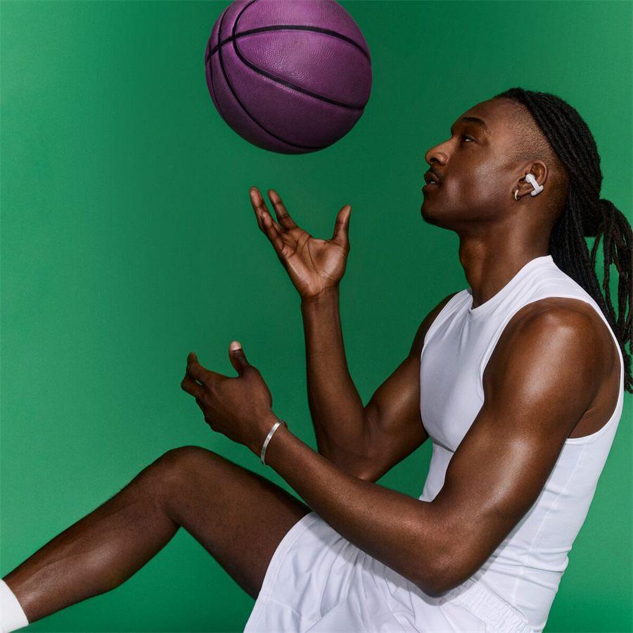 joueur de basket portant les Bose Sport Open Earbuds blanc nuage