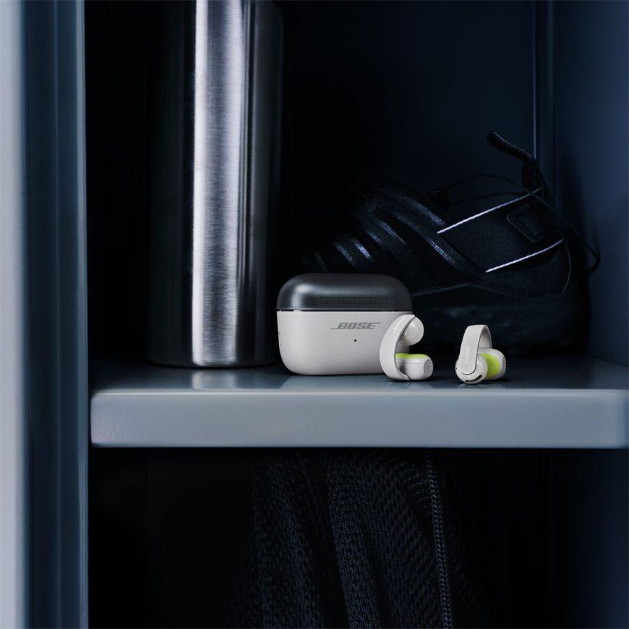 étui et Bose Sport Open Earbuds posés près d'une gourde et d'un sac de sport