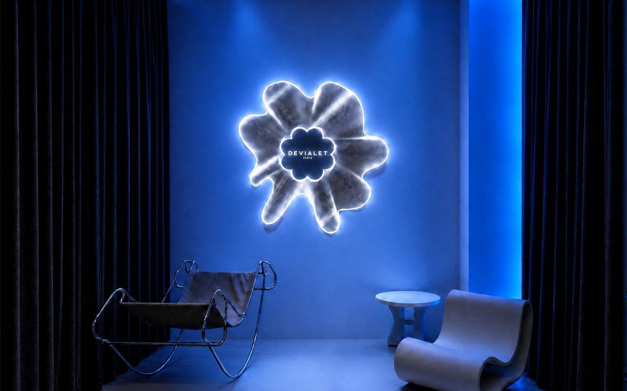 Fleur lumineuse Devialet et deux fauteuils face à face dans une pièce bleue