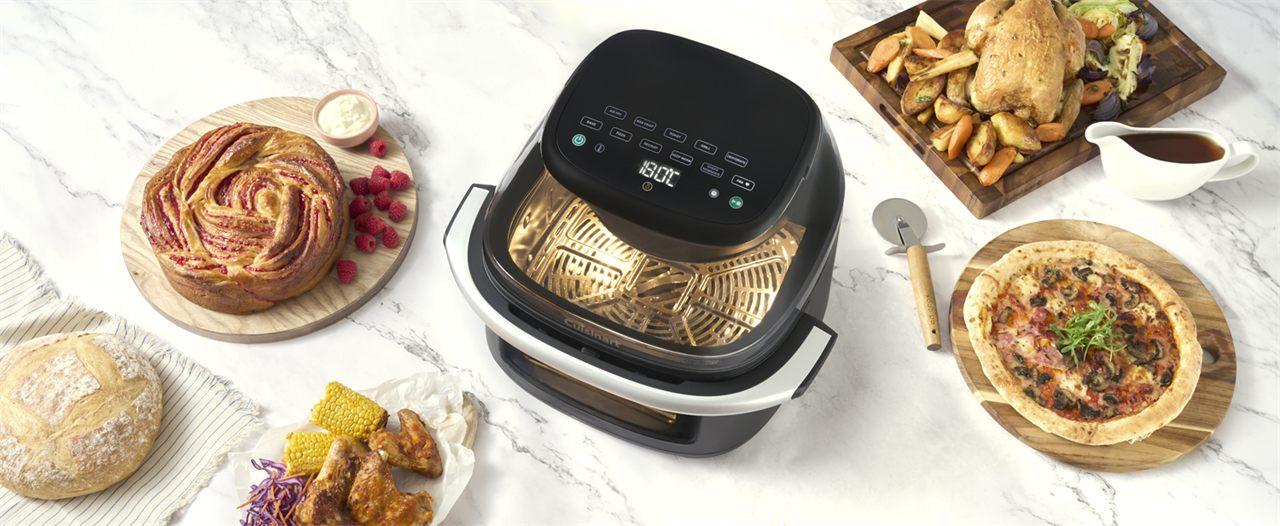 L'airfryer Cuisinart ClearView 9-en-1 entouré d'une pizza, d'un poulet rôti et de pains