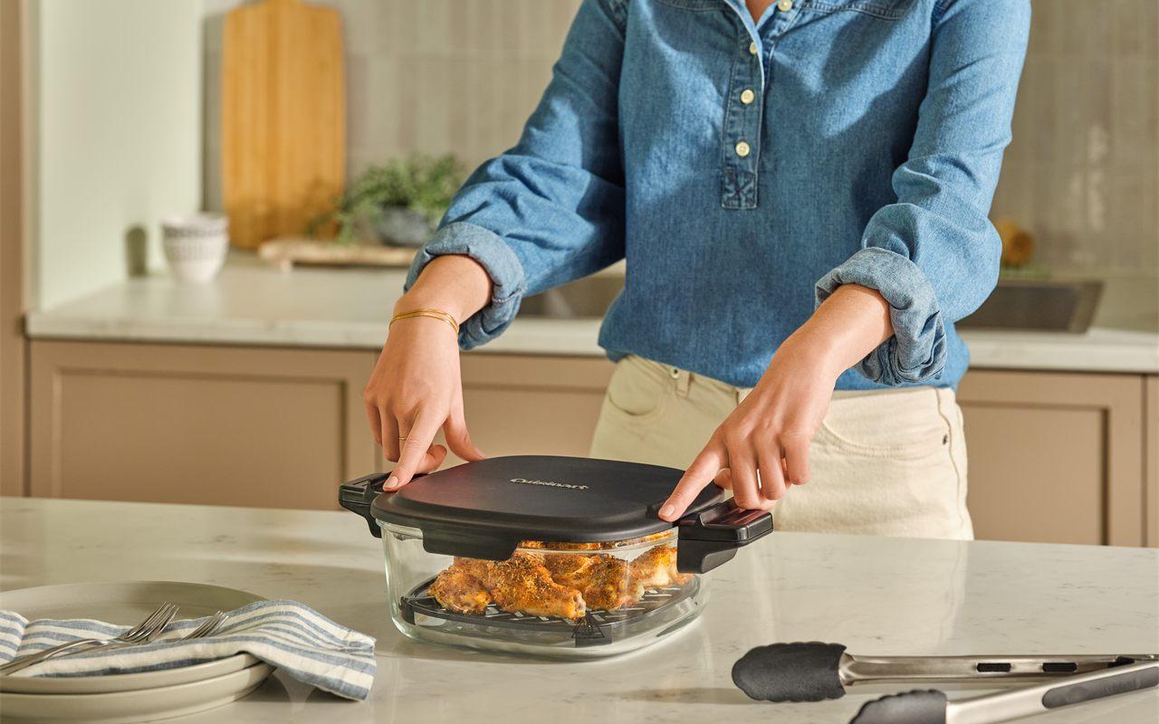 Couvercle posé sur le panier en verre de l'airfryer Cuisinart ClearView 3,8 L contenant du poulet
