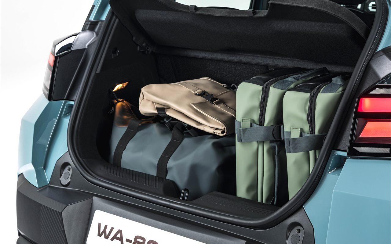 Coffre ouvert de la Dacia Spring chargé de sacs de voyage