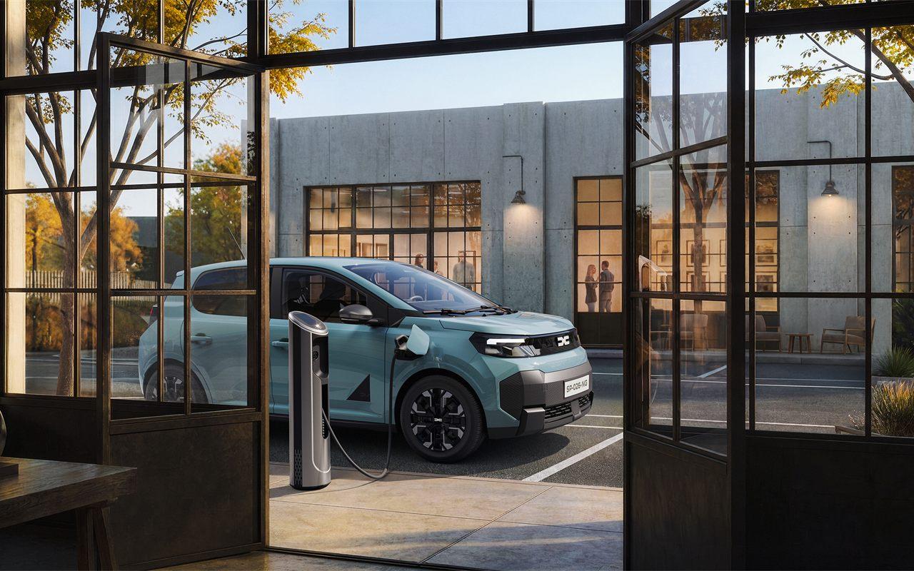La Dacia Spring branchée sur une borne de recharge, vue depuis une verrière