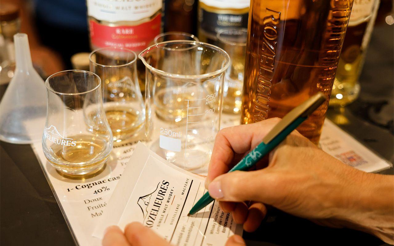 Verres de whisky et notes de dégustation à l'atelier de la distillerie Rozelieures