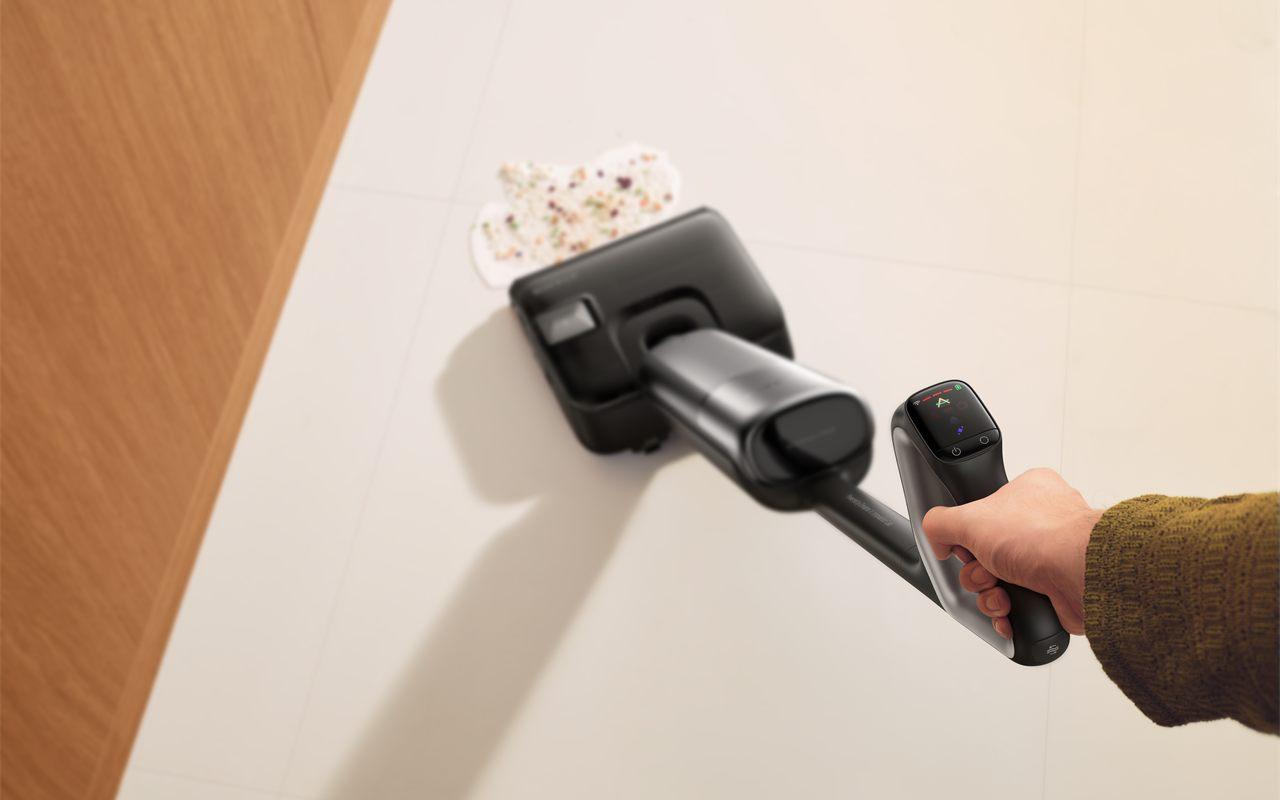 Un aspirateur balai laveur Dreame T Series passe sur une salissure renversée au sol