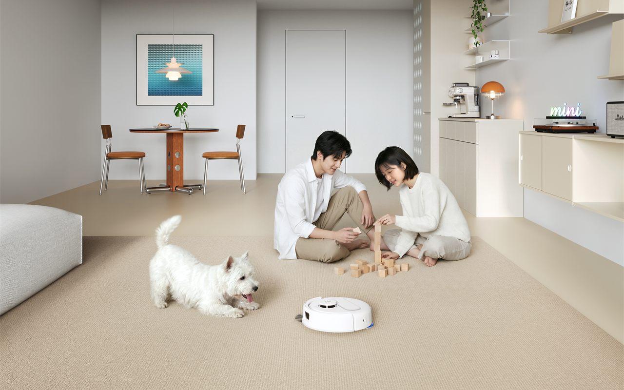 Le DEEBOT mini 2 d'ECOVACS passe dans un salon, à côté d'un chien