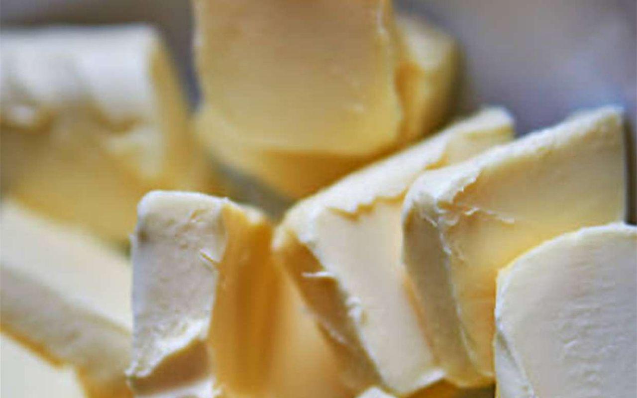 Morceaux de beurre frais dans un bol en inox, la matière première de la glace au beurre noisette