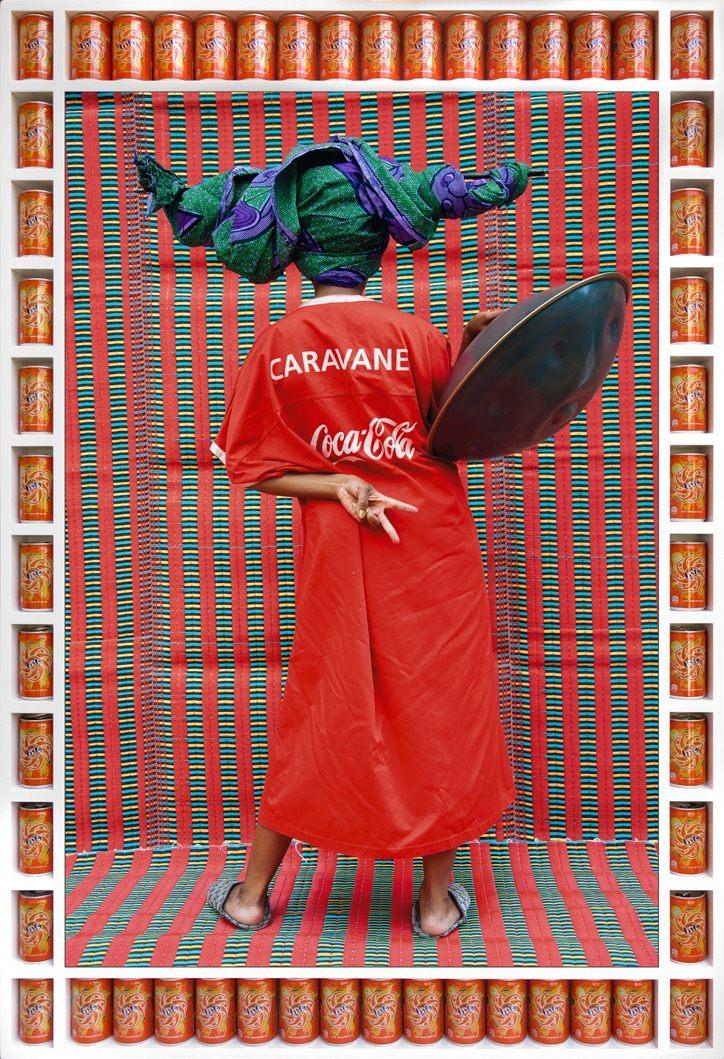 Helen Epega de dos en djellaba rouge, cadre en canettes de soda