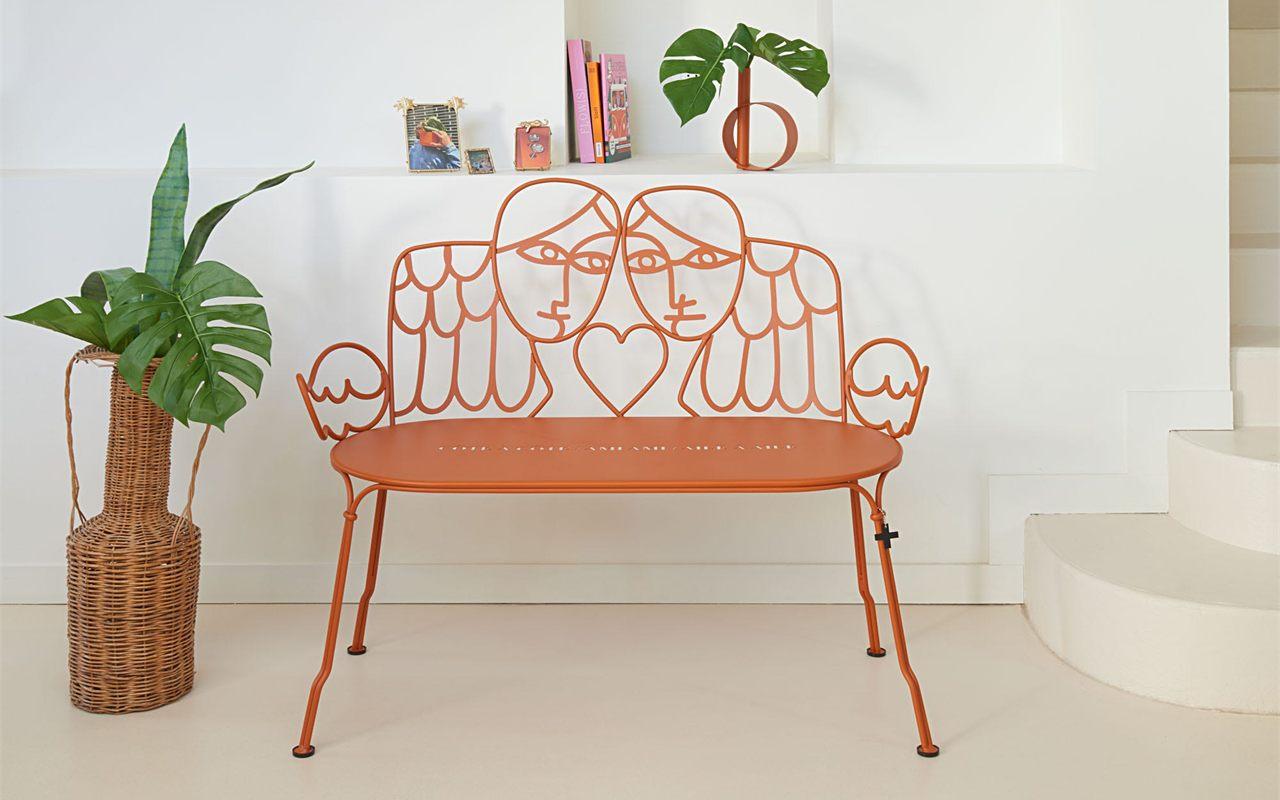 La banquette Aile et Moi dessinée par Castelbajac pour Fermob, en orange, dans un salon blanc