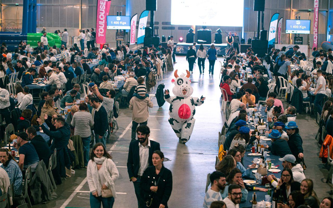 Les écrans géants affichent le total d'aligot consommé au-dessus des tablées de l'Aligofest