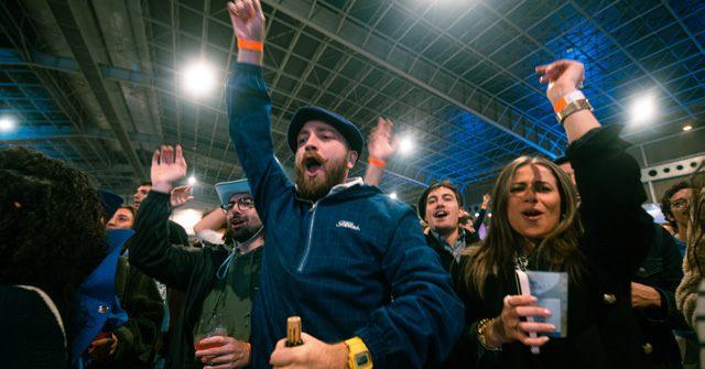 Des participants lèvent les bras pendant un concert de l'Aligofest à Toulouse