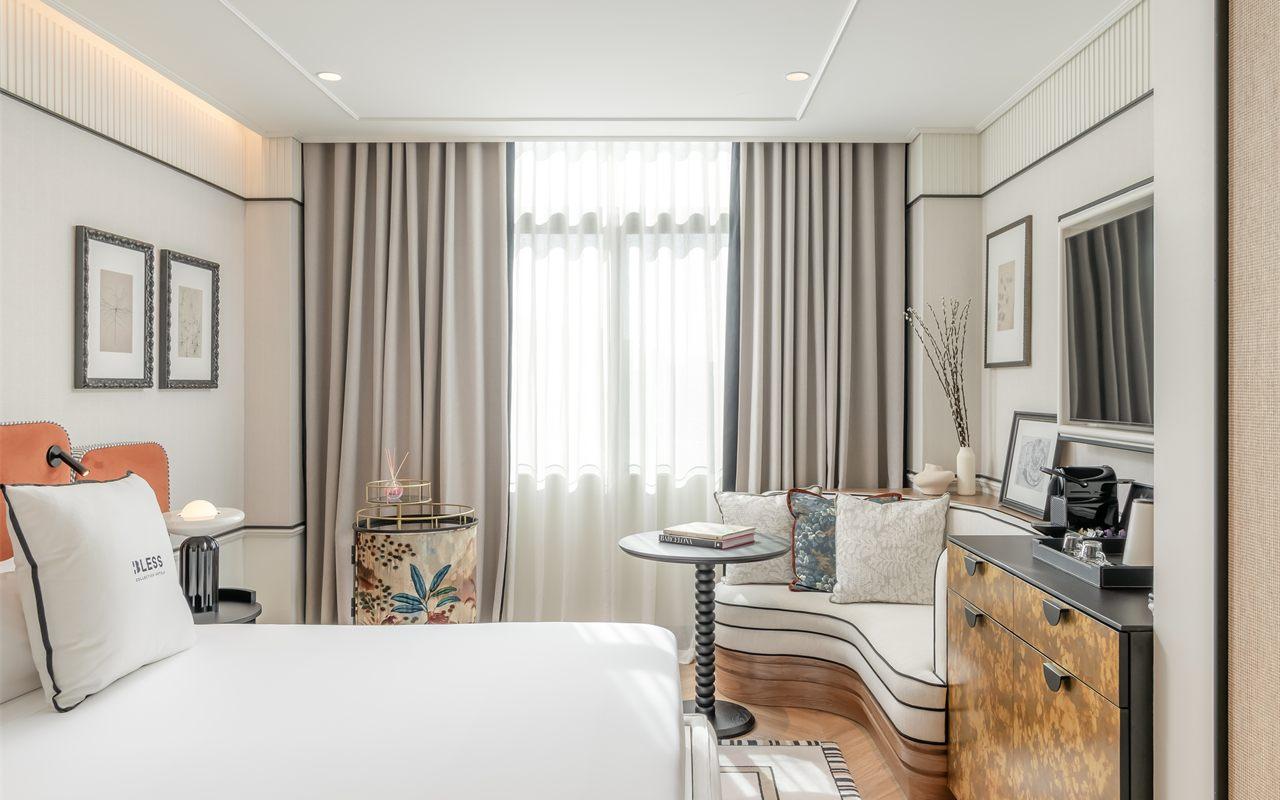 Une chambre de BLESS Barcelona, sa tete de lit orange et son canape arrondi