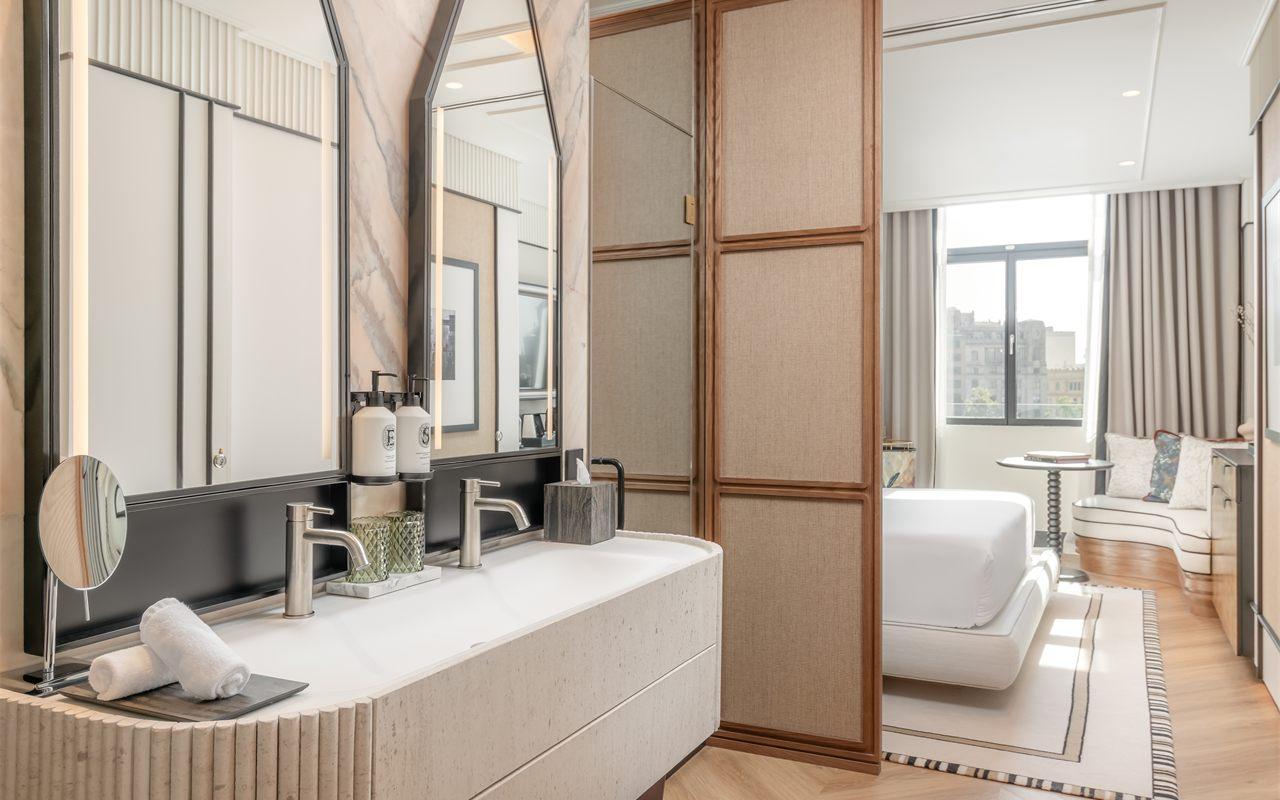 La salle de bains en marbre rose d'une chambre superieure, ouverte sur la chambre