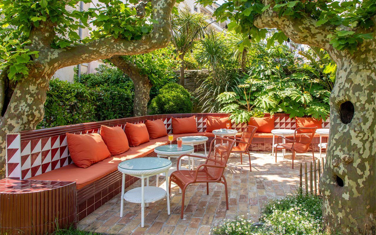 Le jardin de l'Hôtel de Silhouette à Biarritz, banquette orange et carreaux rouges et blancs