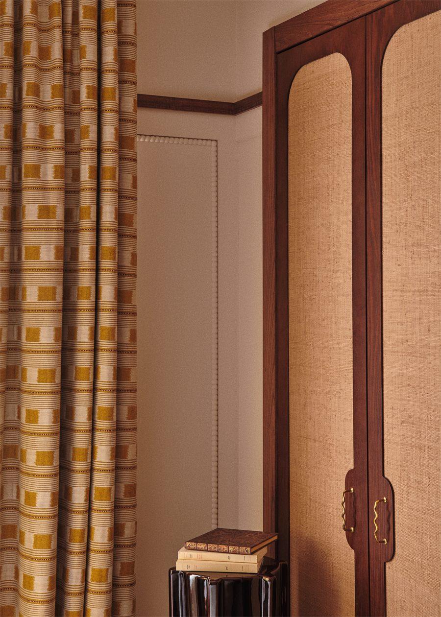 Rideau à motifs ikat et armoire cannée dans une chambre de Maison Silhouette