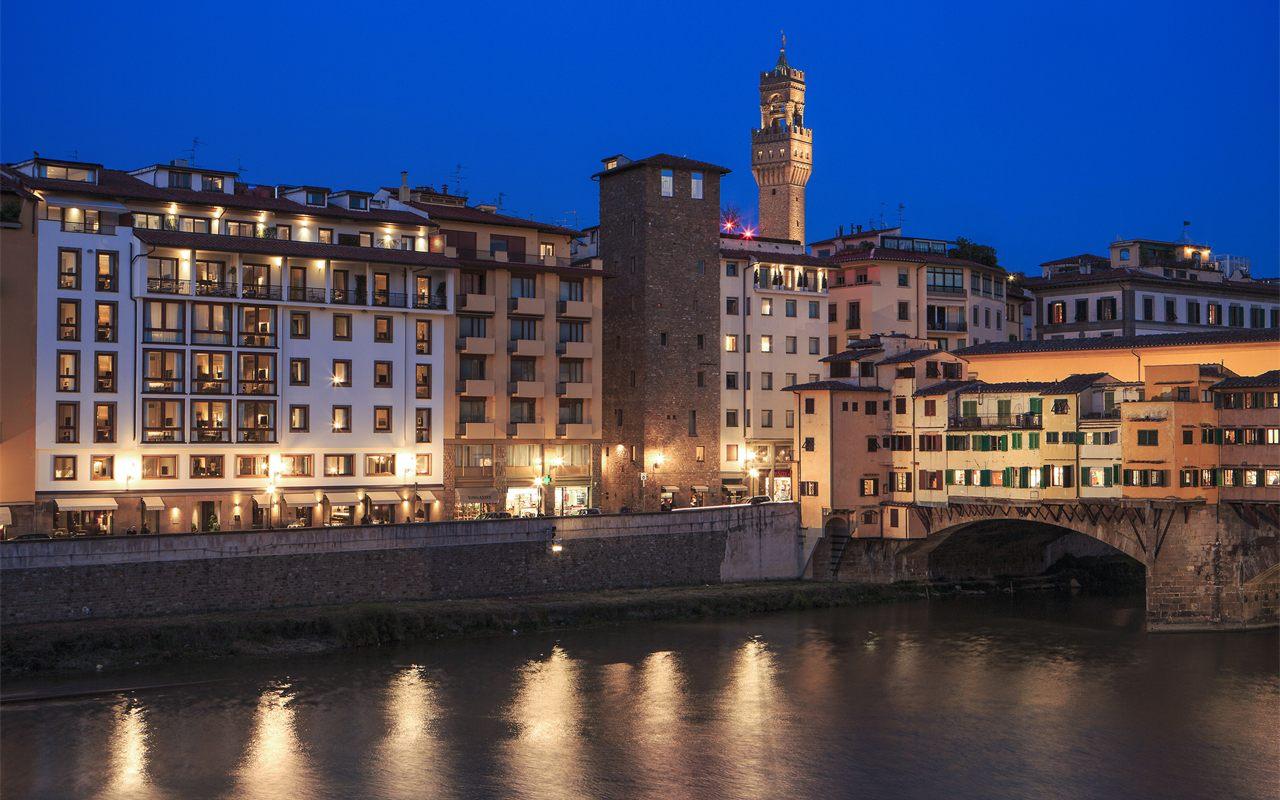 La facade de l'hotel Portrait Firenze eclairee de nuit au bord de l'Arno