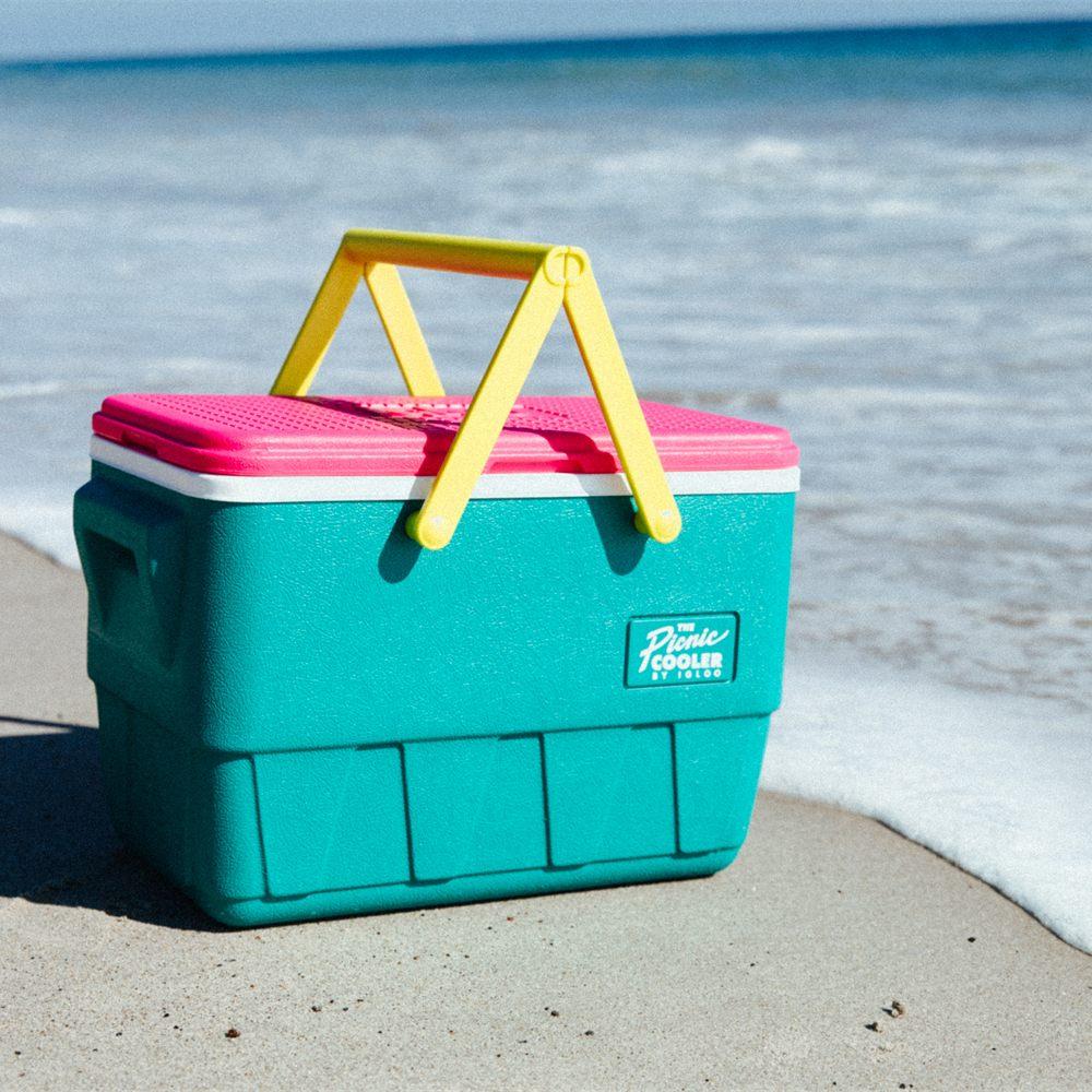 Glacière de pique-nique Igloo Retro turquoise à anses jaunes au bord de l'eau