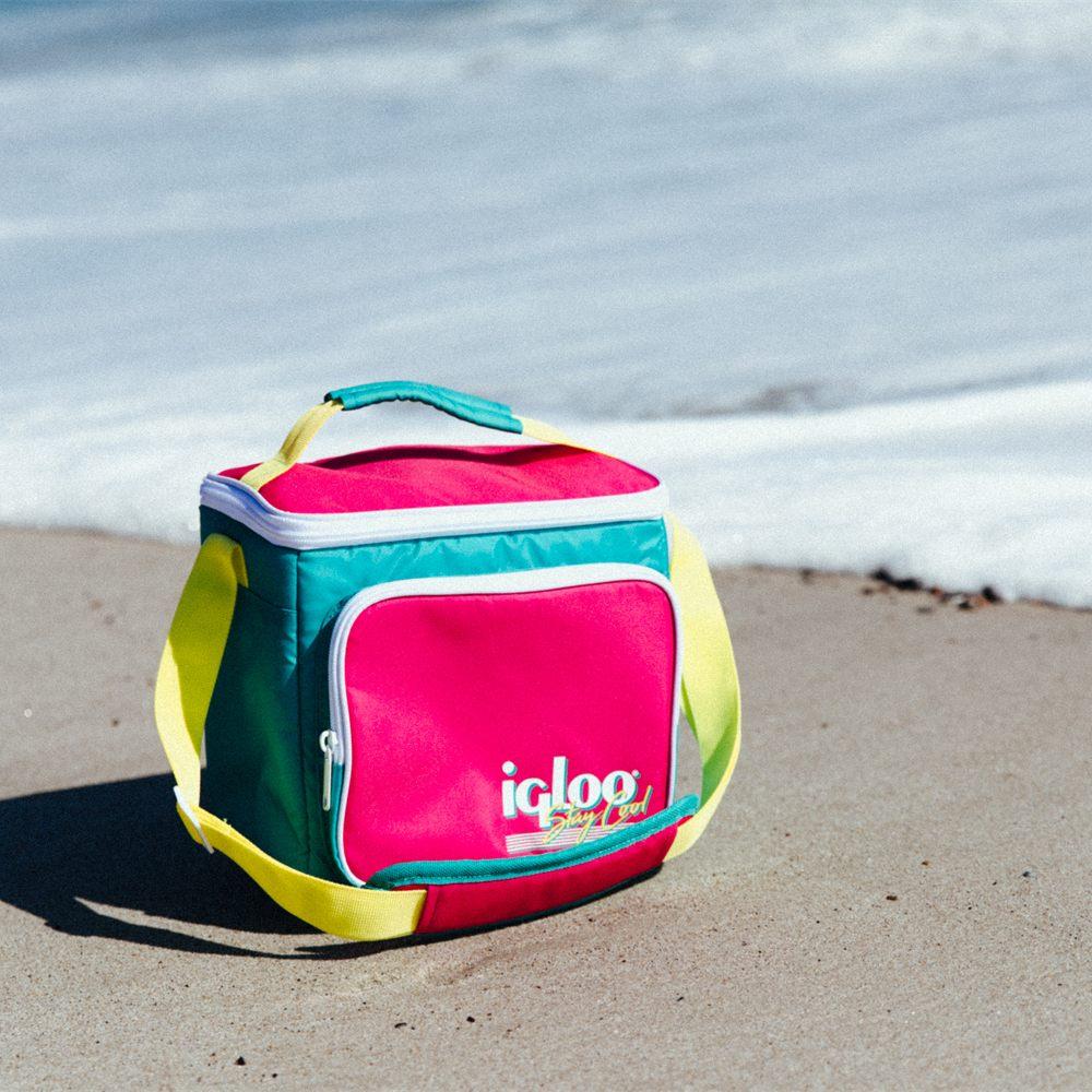 Sac isotherme Igloo Retro rose et turquoise posé sur le sable