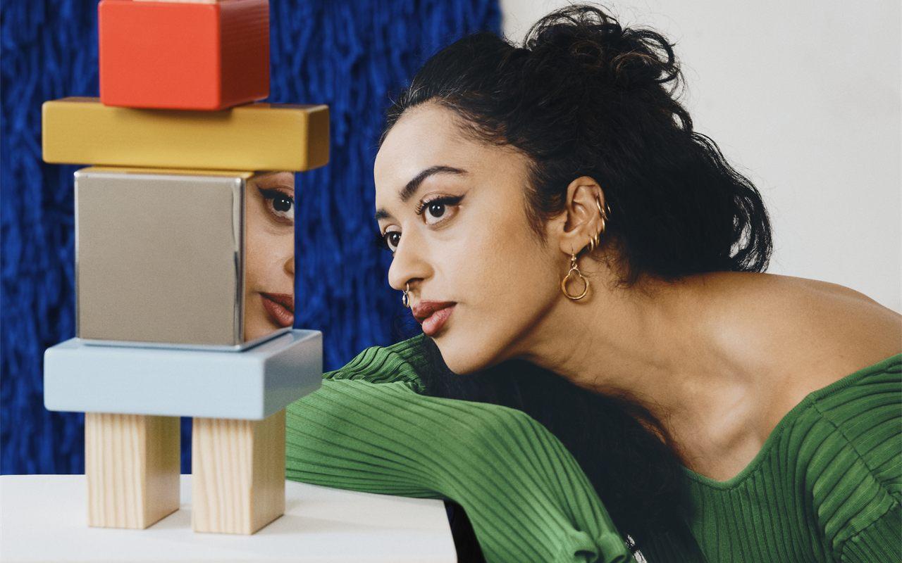 La designer Akanksha Deo aux côtés de sa sculpture de blocs empilés KONSTRUNDA