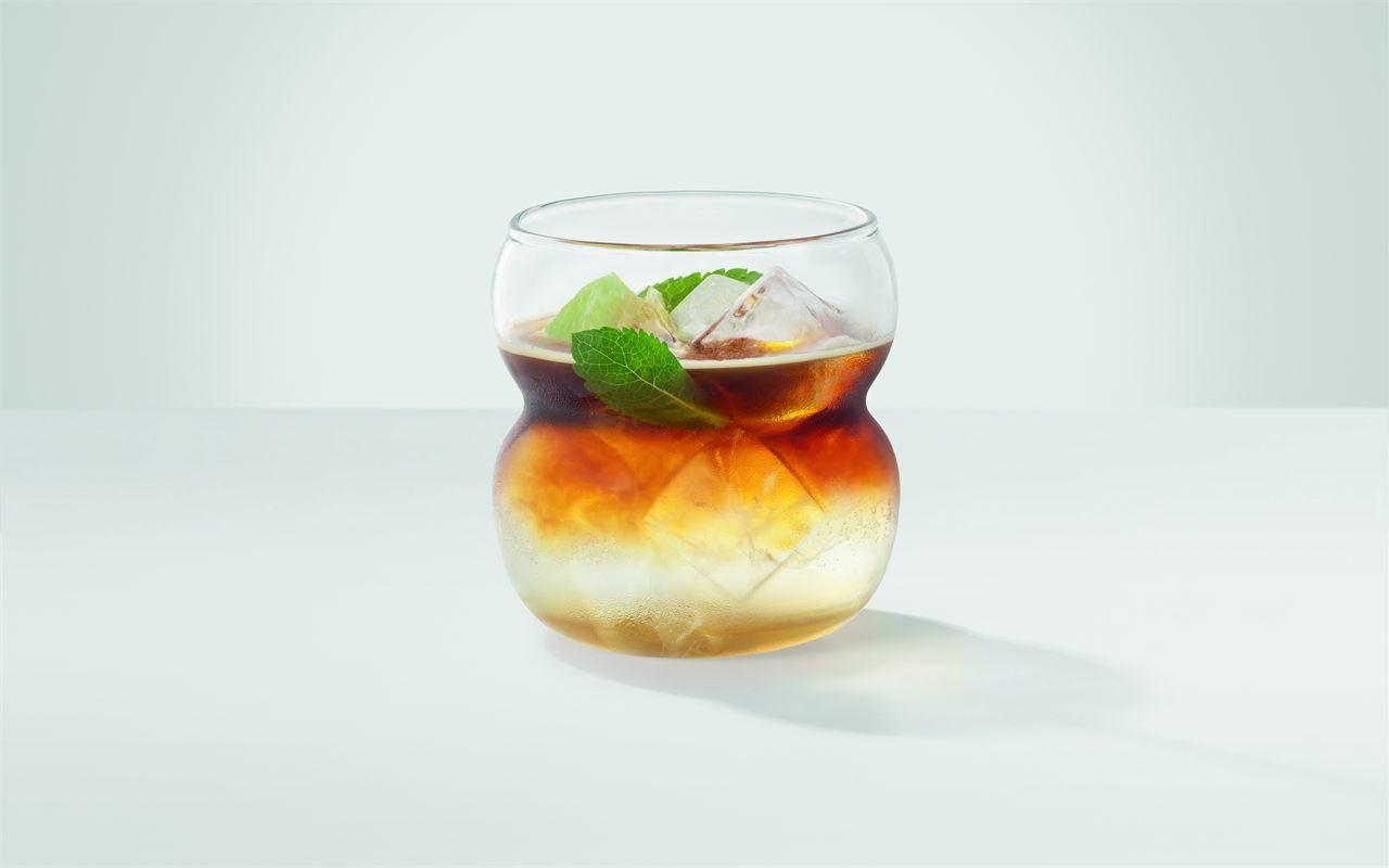 Un cold brew pomme et menthe servi dans un verre, préparé par une machine JURA