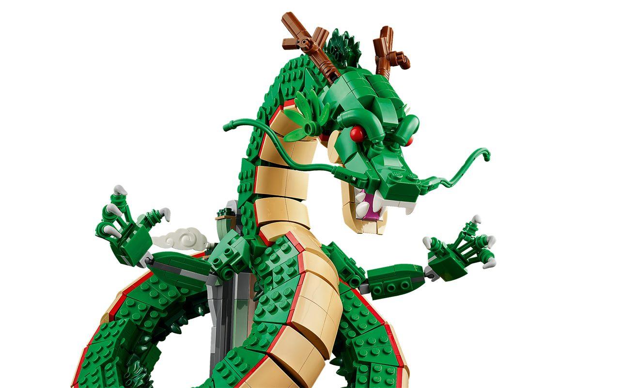 La tête de Shenron en LEGO, yeux rouges, longues moustaches et crocs, entre ses griffes
