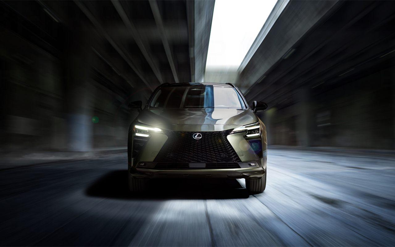 Le Lexus NX de face, feux à LED allumés, en mouvement sous un ouvrage urbain